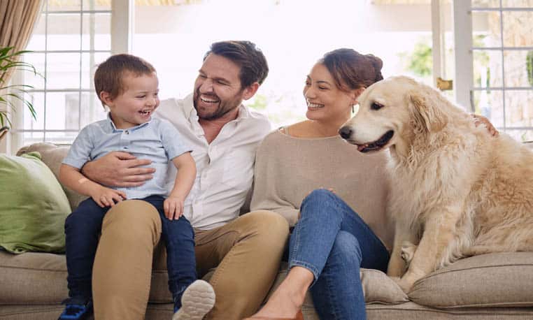 A family waits for an oil delivery on their couch.