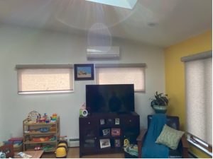A living room with a Mitsubishi Heat Pump and a skylight.